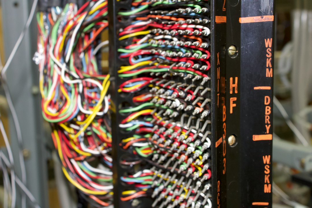 Close de um patch panel com cabos coloridos e terminais etiquetados.